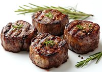 Grilled beef tenderloin medallions with rosemary sprigs and black pepper, showing juicy meat texture and char-grilled marks on white background.
