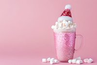 Hot chocolate drink topped with whipped cream and pink glitter winter hat, surrounded by marshmallows on pink background. Perfect for holiday beverage, seasonal marketing, and festive design projects.