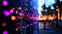 Digital stock market display panel with glowing numbers and data visualization in pink and orange bokeh lights against blurred urban background at night.