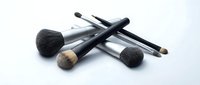 Professional makeup brushes set with black handles on white background, including powder and eyeshadow brushes for beauty and cosmetics application.