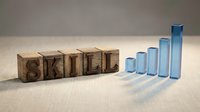 Professional development concept with wooden letter blocks spelling SKILL next to ascending blue glass bars representing growth and progress in abilities.