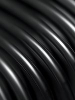 Abstract black metallic surface with flowing curved lines and reflective highlights creating modern industrial texture for contemporary design projects.
