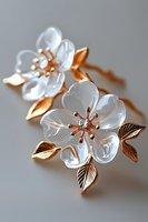 Elegant crystal flower brooch with rose gold leaves and diamond centers on soft gray background, showcasing delicate craftsmanship and luxury jewelry design.