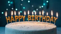 Birthday cake with lit golden letter candles spelling Happy Birthday, glowing against a bokeh blue background, festive celebration concept.