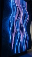Glowing neon light tubes in blue and purple hues create flowing wavy patterns against dark textured wall, suitable for modern tech and futuristic design projects.