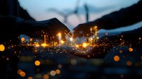 Industrial factory illuminated at night with glowing lights and bokeh effect in foreground creating atmospheric moody scene for business and manufacturing concepts.