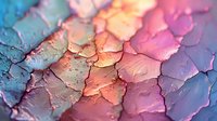 Colorful abstract macro texture of cracked paint surface with pink, blue and peach tones creating artistic pattern. Textural background for creative design.