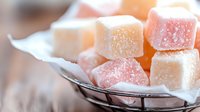 Colorful fruit jelly candies covered in sugar crystals arranged on glass plate, sweet confectionery treats for dessert and snacking occasions.