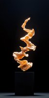 Abstract golden spiral sculpture on black pedestal with dramatic lighting creates dynamic upward movement against dark background. Modern art piece glows warmly.