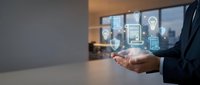 Business professional holding smartphone with digital innovation icons floating above including lightbulb, gears, and data analytics in modern office environment.