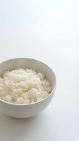 Cooked white rice in ceramic bowl on white background, ready for food photography, cooking blogs, recipe websites, and culinary design projects.