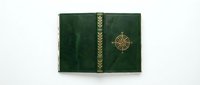 Vintage green leather book cover with ornate golden decorative elements and compass rose emblem on white background isolated for design projects.