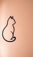 Minimalist black cat silhouette outline on peach background for modern home decor and pet-themed designs.