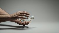 Male hand holding water droplets and bubbles against neutral gray background, representing hydration, freshness, and skincare wellness for cosmetic and health product marketing.