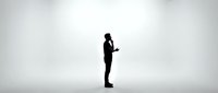 Silhouette of a male professional in business suit standing and gesturing while speaking or presenting against neutral background for corporate training and communication concepts.