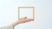 Hand holding empty wooden picture frame against white background for mockup design and creative projects.