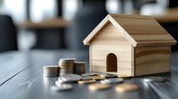 Wooden miniature house with stacked coins on dark table, representing real estate investment, mortgage costs, and property financial planning.