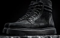 Black suede lace-up boot with chunky sole, isolated on dark background. Professional footwear product photography for e-commerce, fashion catalogs, and retail marketing.