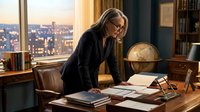 Professional businesswoman with glasses reviewing documents in executive office with city skyline view during golden hour for corporate presentations.