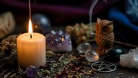 Mystical altar setup with burning candle, crystals, pentagram, herbs and ritual tools for spiritual practices, witchcraft ceremonies and esoteric healing.