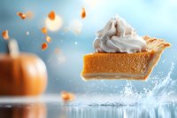 Levitating slice of pumpkin pie with whipped cream topping against blurred autumn background with water splash and floating crumbs in magical setting.
