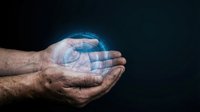 Male hands holding glowing digital hologram sphere against dark background. Concept for technology, innovation, data protection, and future business solutions.