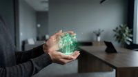 Businessman holding glowing green digital brain hologram in modern office representing artificial intelligence and innovative technology solutions.
