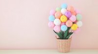 Colorful cotton candy bouquet arranged in wicker basket with green leaves against pink wall background, creative sweet food art concept for celebration decor.