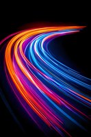 Dynamic curved light trails in vibrant neon colors creating flowing motion effect on black background for modern digital design projects.