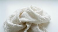 Crumpled beige linen fabric isolated on white background, suitable for textile design, fashion mockups, and product presentations.