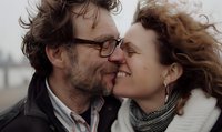Intimate close-up of mature couple sharing tender moment outdoors, curly hair blowing in wind, genuine emotions and natural connection captured in lifestyle setting.