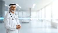 Middle Eastern male doctor in traditional white keffiyeh and medical coat with stethoscope standing confidently in modern hospital corridor for healthcare concepts.