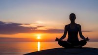 Woman silhouette meditating in lotus pose at sunset by ocean. Peaceful yoga practice with golden sky reflection on water for wellness and mindfulness concepts.