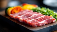 Raw marbled beef steak on wooden cutting board with fresh colorful bell peppers and herbs, selective focus on meat texture showing premium quality.