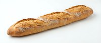 Fresh baked French baguette with golden crust and flour dusting isolated on white background for bakery and food design projects.