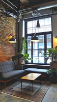 Modern industrial loft interior with exposed brick wall, large windows, gray sofa, wooden coffee table, pendant lights and indoor plants creating cozy urban atmosphere.
