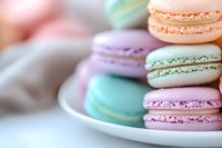 Colorful French macarons in pastel pink, purple, mint green, and peach shades stacked on white plate, soft focus background creates dreamy dessert composition.