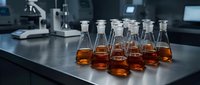Amber liquid samples in laboratory glass bottles arranged on metal table with scientific equipment in background for research and testing.