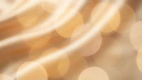 Soft golden light streaks with warm bokeh circles create an elegant, blurred abstract background suitable for overlays and design projects.