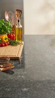 Kitchen counter with fresh vegetables, herbs, olive oil and copper cooking utensils on wooden cutting board with copy space for culinary content.