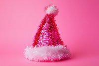 Festive pink Santa hat with white fluffy trim and sparkly sequins isolated on bright pink background. Holiday season celebration accessory for Christmas party.