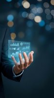 Businessman hand displaying holographic financial data dashboard with charts and graphs against bokeh lights background for business analytics presentations.