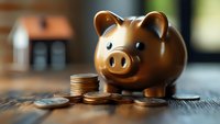 Bronze piggy bank with stacked coins on wooden table, shallow depth of field creates soft background blur for financial and savings concepts.