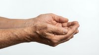 Elderly man's weathered hands cupped together in protective gesture on white background, showing age spots and wrinkles, isolated for design use.