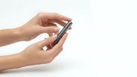 Close-up of female hands holding smartphone on white background, isolated for digital communication and mobile technology design projects.