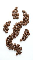 Roasted coffee beans arranged in decorative pattern on white background isolated for cafe menu design and beverage branding projects.