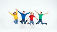 Four diverse children jumping with arms raised wearing colorful shirts against white background. Happy kids in mid-air expressing joy and excitement.