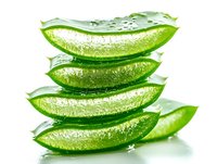 Fresh aloe vera plant slices stacked with water drops on white background, showing transparent gel texture for natural skincare and wellness products.