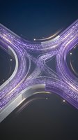 Aerial view of illuminated highway interchange at night with purple and white light trails from vehicle traffic creating dynamic patterns for transportation and urban infrastructure concepts.