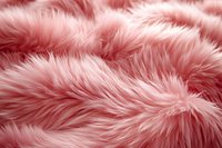 Soft pink faux fur texture background with fluffy waves and gentle shadows creates luxurious textile surface for fashion and interior design projects.